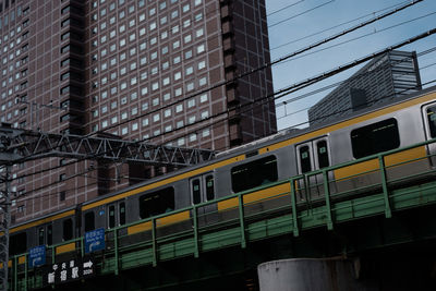 Low angle view of train against buildings in city