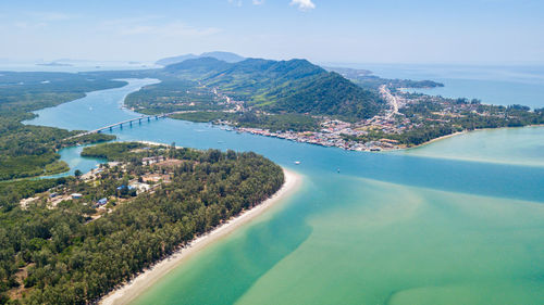 Aerial view of townscape by sea against sky