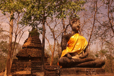 Statue of buddha against trees