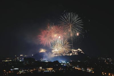 Firework display above buildings in city at night