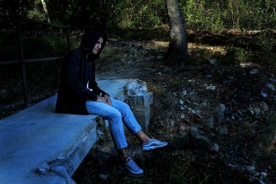 Rear view of a man sitting on tree