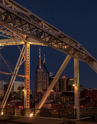 Low angle view of illuminated bridge against sky at night