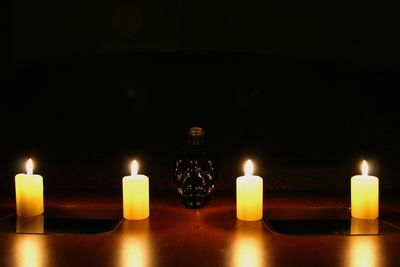 Close-up of lit tea light candles in the dark