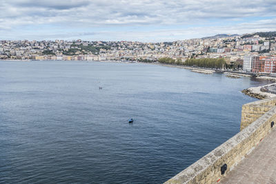 High angle view of townscape by sea against sky