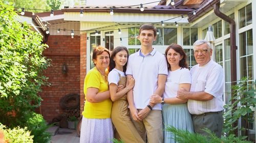 Cheerful family standing against house