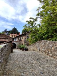 Old building by trees against sky