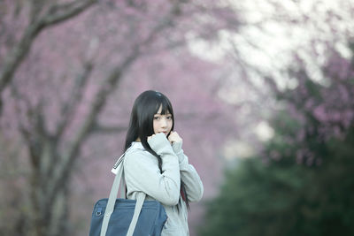 High angle view of woman standing by cherry blossom tree