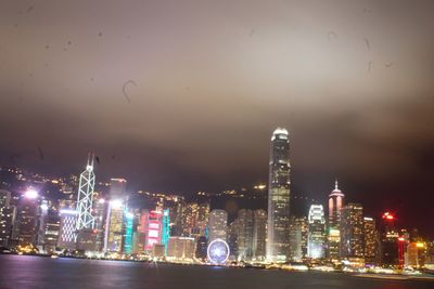 Illuminated buildings in city against sky at night