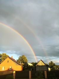 Rainbow over buildings against sky