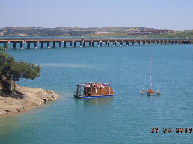 water, transportation, built structure, nautical vessel, bridge - man made structure, connection, architecture, sea, clear sky, river, waterfront, boat, mode of transport, tranquil scene, tranquility, travel, mountain, nature, bridge, day