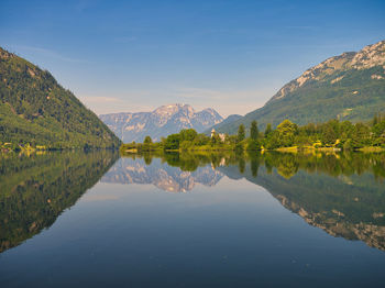 Scenic view of lake and mountains against blue sky