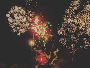 Low angle view of firework display at night