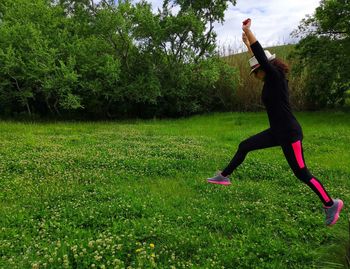 Girl jumps among the green countryside