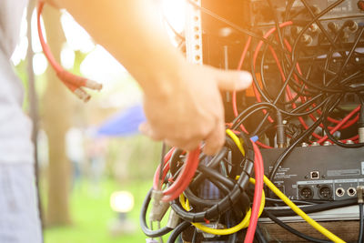 Close-up of man holding tangled cables of machinery