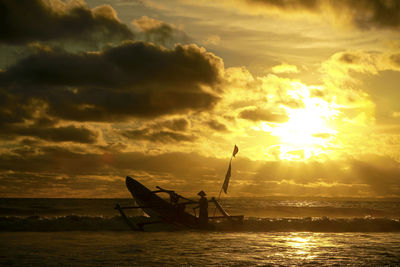 Silhouette boat in sea against sky during sunset