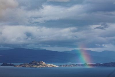 Scenic view of rainbow over sea against sky