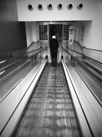 Full length of woman standing on escalator