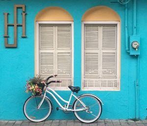 Bicycle against blue wall of building