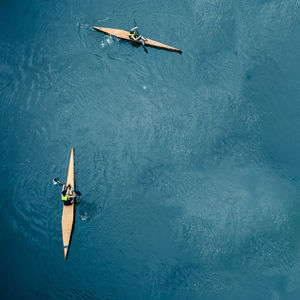 High angle view of people canoeing in sea