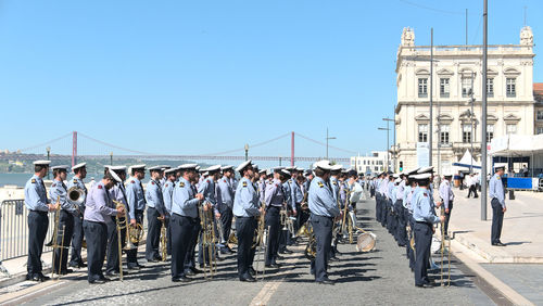 Military march in commerce square in front of april 24 bridge on tagus river in lisbon
