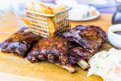 Close-up of potato chips and pork rib on table