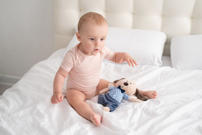 Cute baby boy sleeping on bed at home