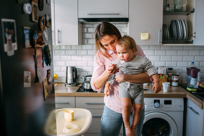 Mom feeds a small child at home with yogurt from a spoon. family concept