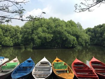 Boats moored in lake against sky