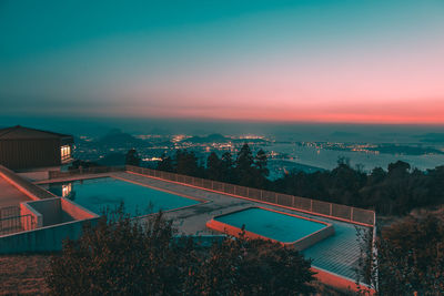 Aerial view of houses and trees against sky during sunset