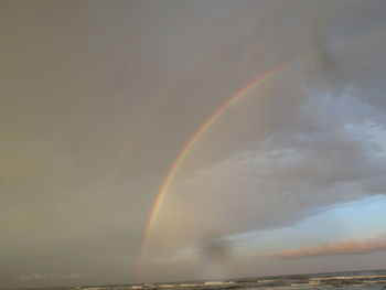Low angle view of rainbow over sea against sky