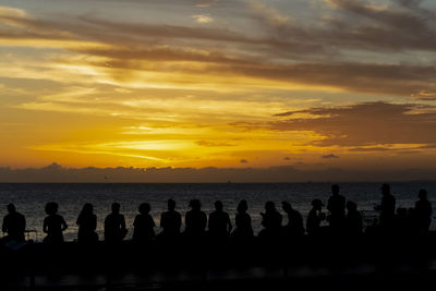 Silhouette of a person at the yellow sunset. beach of rio vermelho, salvador, bahia, brazil.