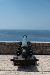 Coin-operated binoculars by sea against sky