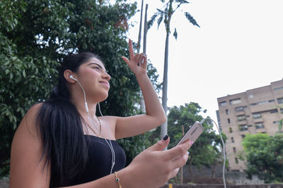 Woman listens to music through a mobile device while moving her arms .