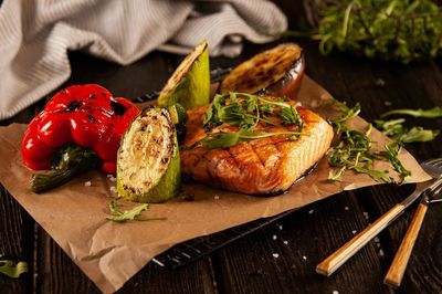 Close-up of grilled fish meat and vegetables fried on coals