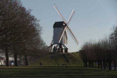 Traditional windmill on field against clear sky