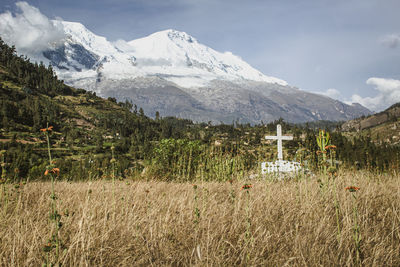 Cross in yungay cemetery looking to the huascaran mountain 