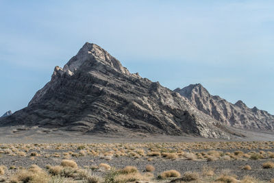 Scenic view of rocky shark tooth like mountains with nice grass in the foreground and clear blue sky