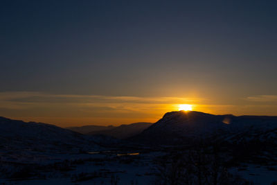 Scenic view of snowcapped mountains against sky during sunset