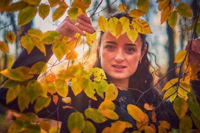 Portrait of young woman with autumn leaves