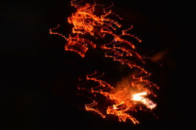 Close-up of bonfire against clear sky at night