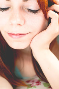 Close-up portrait of young woman with eyes closed