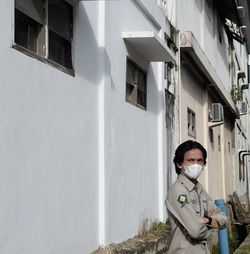 Portrait of woman standing outside house