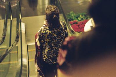 High angle view of young woman moving down on escalator