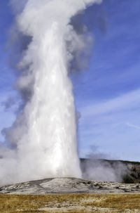 Water spraying against sky