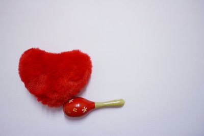 High angle view of red berries on table against white background
