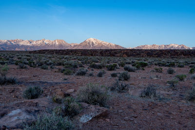 First light of morning on distant mountains over vast desert valley 