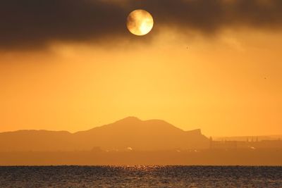 Scenic view of sea against orange sky