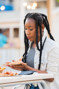 Low section of woman holding ice cream in restaurant