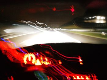 Low angle view of illuminated lighting equipment at night