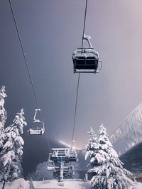 Low angle view of ski lift against sky during winter at night